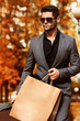 © ASjack - Handsome man in suit with shopping bags. Autumn.