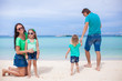 © travnikovstudio - Family of four walking by the sea and enjoy beach vacation