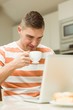© WavebreakMediaMicro - Man drinking coffee using laptop