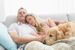 © WavebreakmediaMicro - Loving couple sitting on couch with their dog