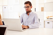 © Monkey Business - Businessman Using Laptop In Office Of Start Up Business