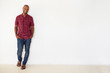 © Monkey Business - Portrait Of Casually Dressed Man Leaning Against White Wall