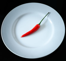 Red Chili On White Plate Isolated On Black