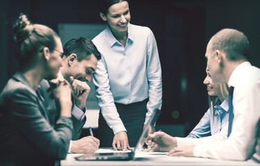 smiling female boss talking to business team