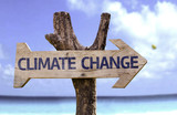 Fototapeta  - Climate Change wooden sign with a beach on background