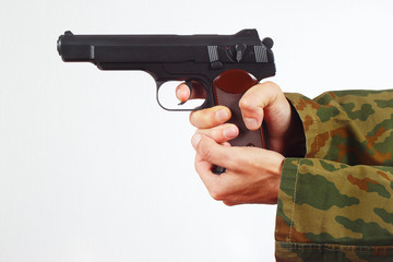 Hands in camouflage uniform with gun on a white background