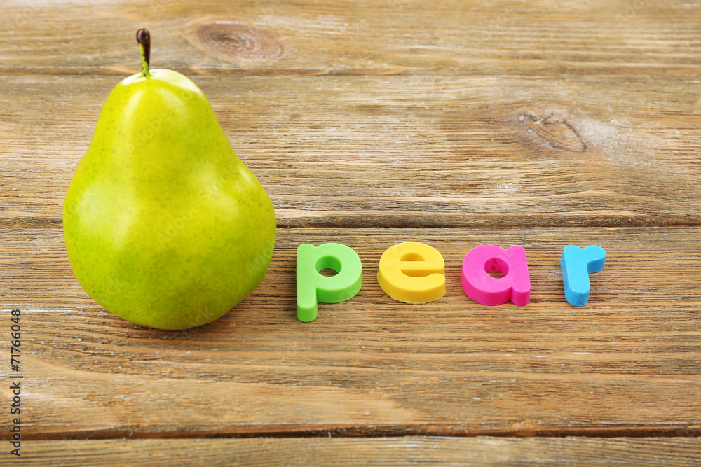 Pear word formed with colorful letters on wooden background