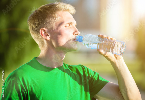 Tired man drinking water from a plastic bottle after fitness - Buy this ...