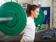 © Tyler Olson - Fit Woman Lifting Barbell in Gym