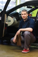 Poster - Worker on a car wash cleaning car interior