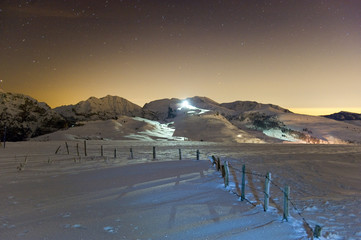 Wall Mural - mountain scene with ski slopes at night.