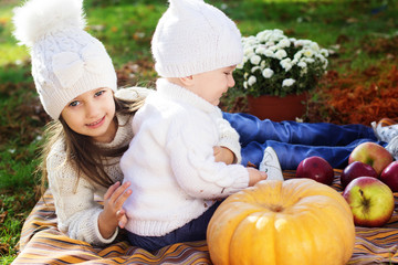 Baby boy with sister in autumn park