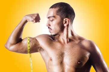 Wall Mural - Muscular man measuring his muscles