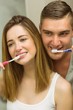 © WavebreakMediaMicro - Cute couple brushing their teeth