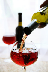 Canvas Print - Red wine pouring into wine glass, close-up