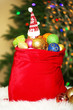 Red bag with Christmas toys on Christmas tree background