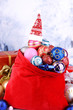 Red bag with Christmas toys on winter background