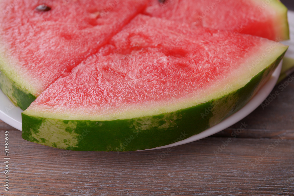 Slices of watermelon on plate on wooden table