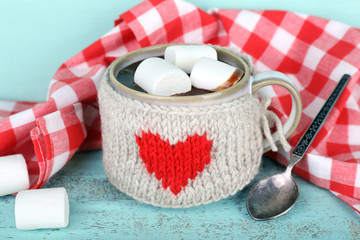 Fototapete - Cup of tasty hot cocoa, on wooden table, on color background