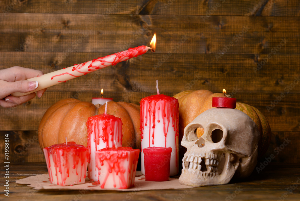 Process of lighting candles for Halloween party. Female hand