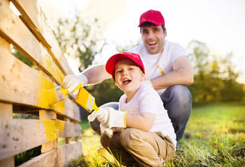 Father and son painting fence