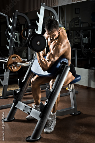 Fototapeta na wymiar Umięśniony atrakcyjny mężczyzna na siłowni