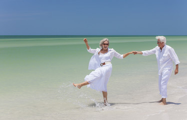 Wall Mural - Happy Senior Couple Dancing Holding Hands on A Tropical Beach