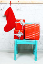Christmas Presents On Blue Chair On Brick Wall Background