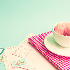 Wall Mural - Pink macaroons in a tea cup and vintage postcards