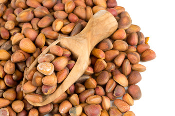 Poster - pine nuts in a wooden scoop isolated on white background