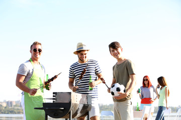 Wall Mural - Young friends having barbecue party, outdoors