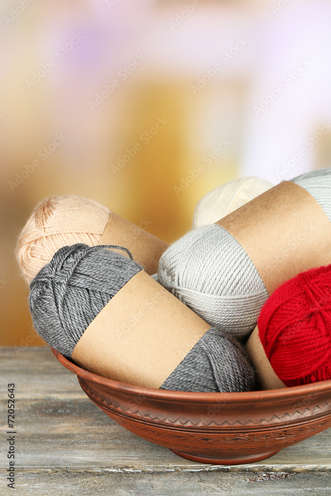 Knitting yarn on wooden table, on light background