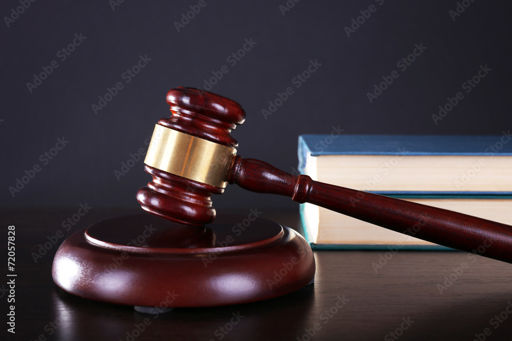 Judge's gavel and books on dark grey background