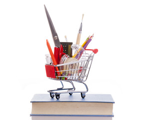 Shopping cart full of school material, isolated on white backgro