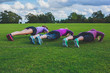 Three women doing push ups in park