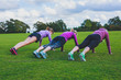 © LoloStock - Three women doing push ups in park