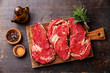Raw fresh meat Ribeye steak entrecote and seasoning on dark wood
