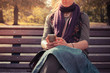 Young woman on park bench using her phone