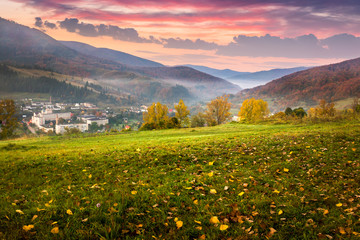 village on hillside meadow with foliage in mountain at sunrise