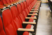 Oblique View Over A Row Of Red Theatre Seats At A Movie Theatre