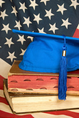 Poster - blue graduation cap on books with flag