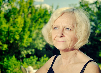 Wall Mural - Mature, blonde woman in garden.