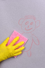 Wall Mural - Hand in glove wiping children drawing on wallpaper