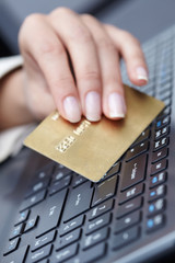 woman holding credit card on laptop for online shopping concep