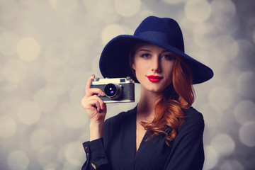 Wall Mural - Style redhead women with sunglasses and vintage camera.