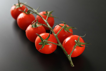 Cherry tomatoes on green branch