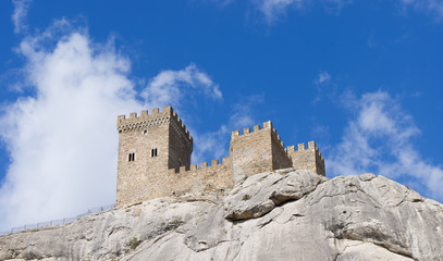 The tower of the ancient castle on a blue sky background