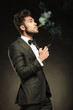 © Viorel Sima - young business man blowing smoke while holding a cigarette