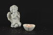Ornamental angels with heart candle isolated on black