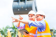 © Kzenon - Asian engineer discussing plans on construction site